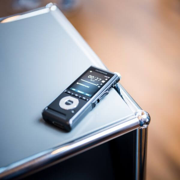 Photo of the Olympus DS-2600 on the edge of a metal stand | featured image for Olympus DS-2600 Business Dictation Recorder.