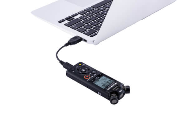 Photo of a dictation and transcription device connected to a computer | Featured Image for Olympus Premium Dictation and Transcription Bundle Product Page by Pacific Transcription.